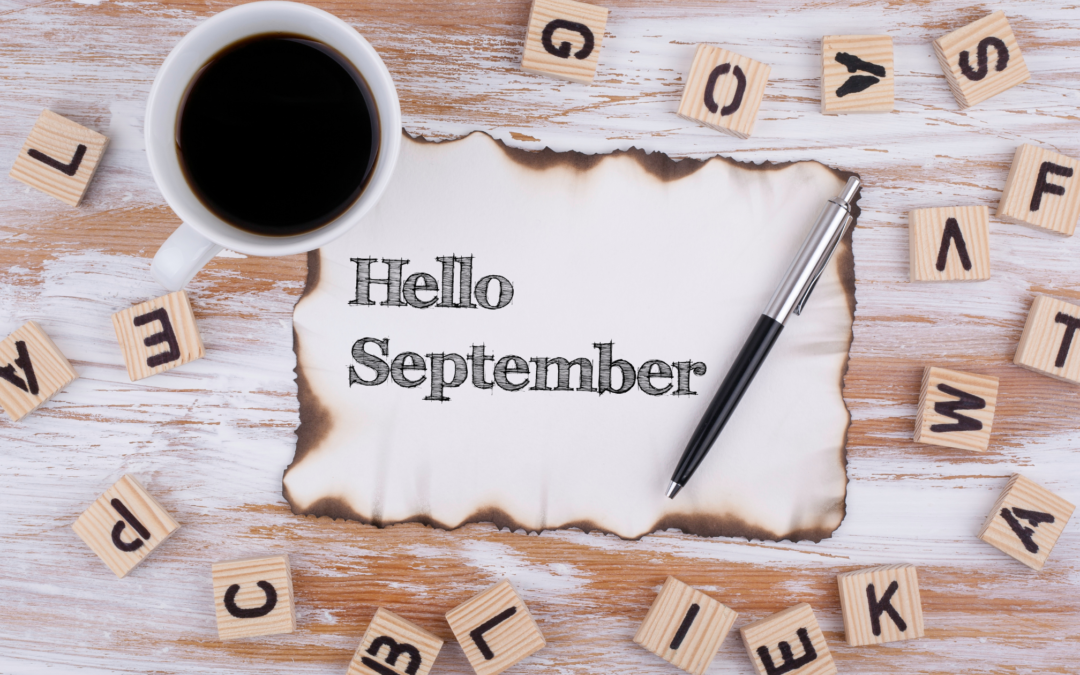 image of table with scrabble pieces, coffee and a scrap of paper with burnt edges that reads: Hello September